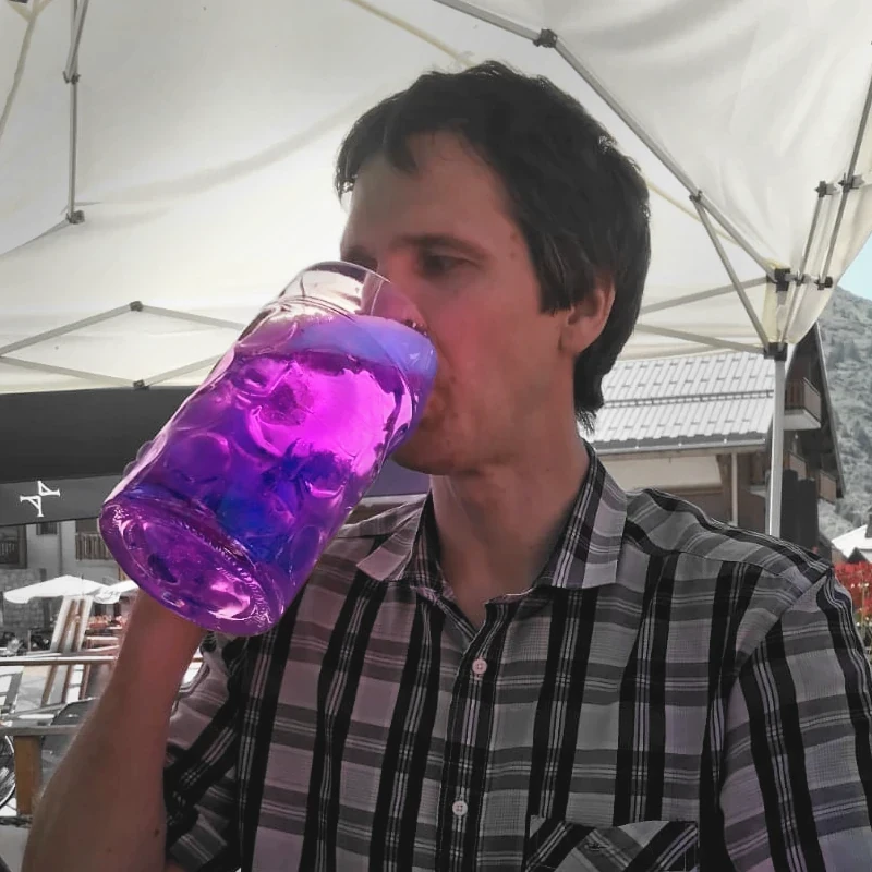 WizoCat's creator drinks from a big mug filled with a glowing purple liquid.